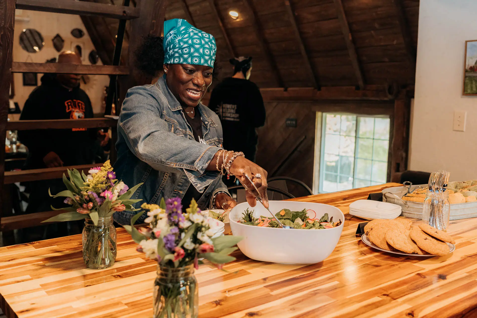 A guest serving fresh salad from the catered spread in the barn loft