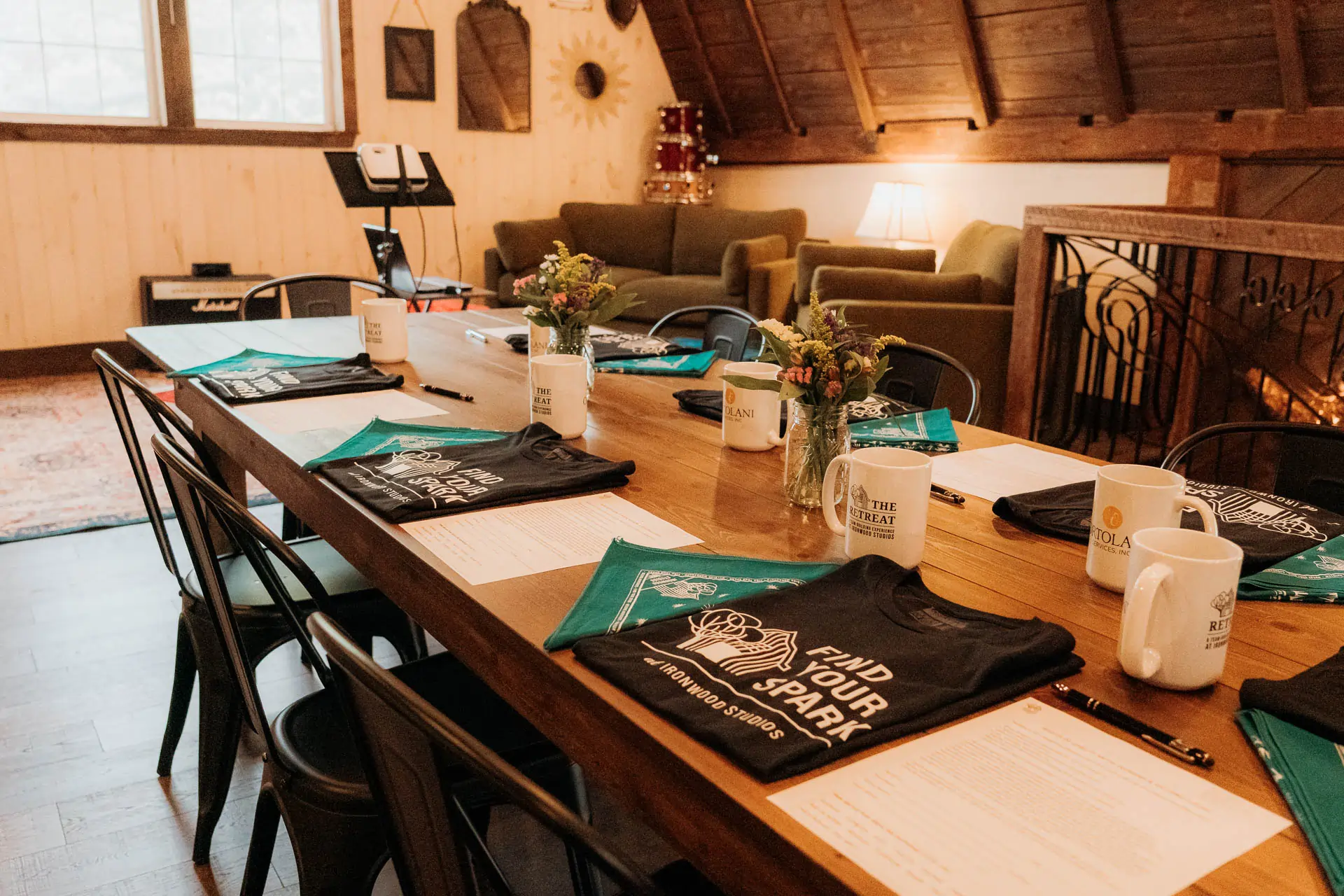 Barn meeting table set with branded Ironwood shirts, mugs, and event swag
