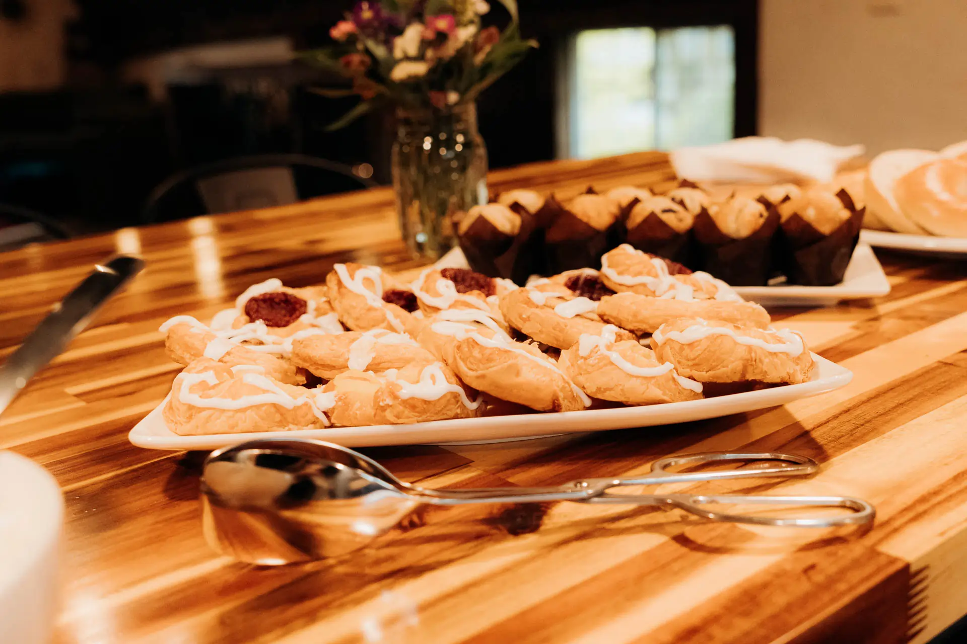 Catered pastries and refreshments laid out on a butcher block counter