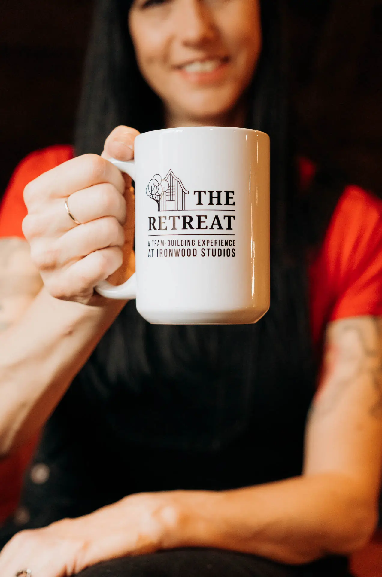 Guest holding a branded The Retreat at Ironwood Studios mug